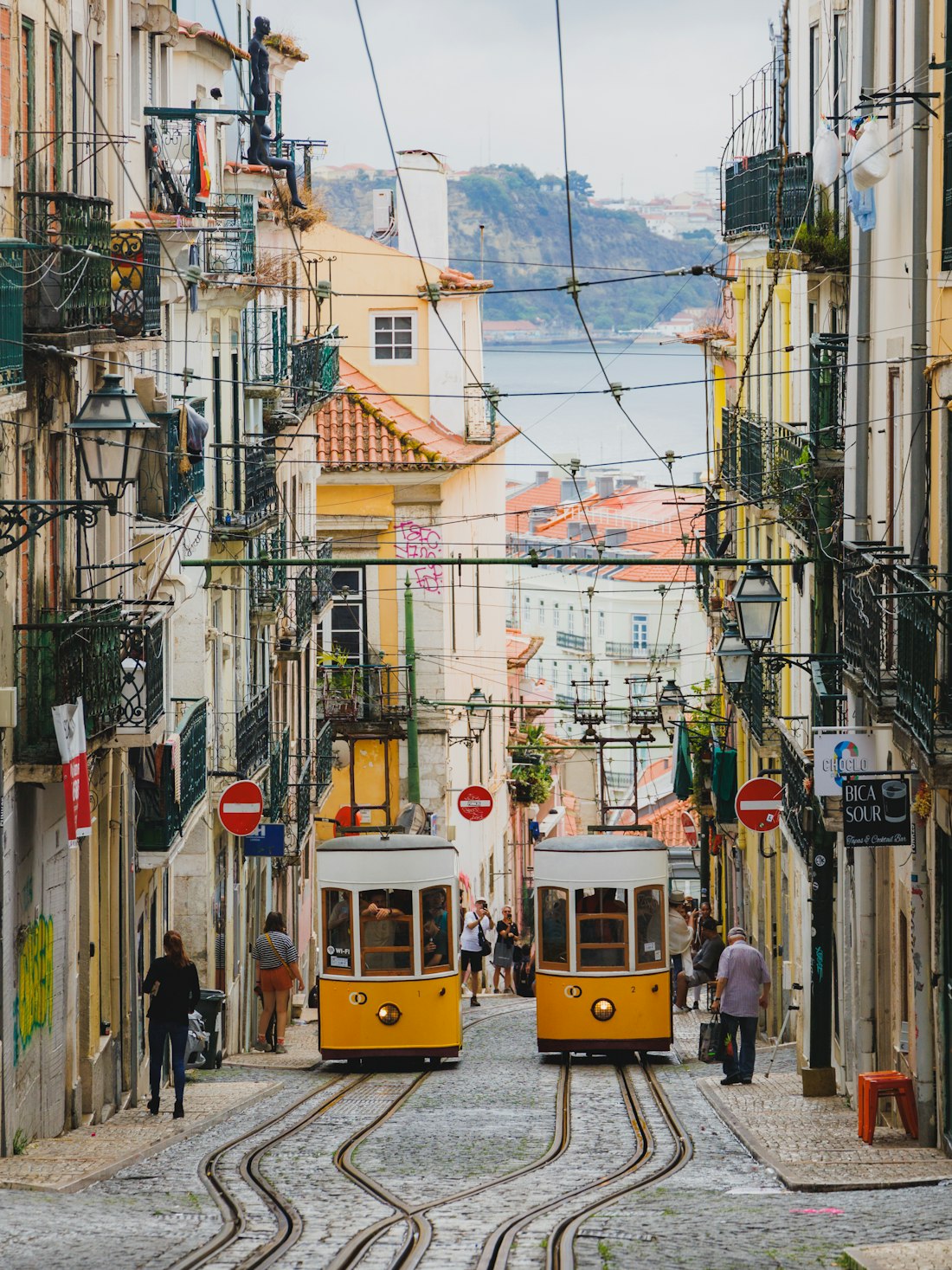 Tranvías amarillos subiendo una calle empinada de Lisboa