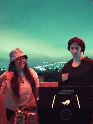 Vanessa y un compañero de DJ en una terraza de noche
